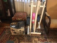 Glider machine with rubber padded pedals and pink central housing, with exercise pedaler box visible next to it.