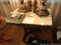 Full view of the side table showing marble top, carved wood base, and items on table (not included).