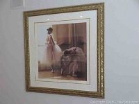 Full view of the matted print showing two ballerinas behind glass in an ornate gold frame.