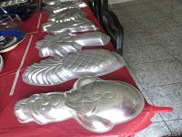 Table with the metal cake pans including a snowman, pineapple, and pumpkin shape pans visible