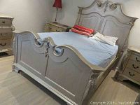 Assembled queen bed frame showing footboard in front and headboard behind