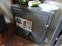 Full view of the black metal safe with keypad and handle, showing size and condition.