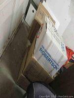 Six stacked cardboard boxes in storage area