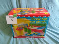 Front view of unopened Fisher Price Picnic Set in original colorful box with labeled front and image of picnic utensils and tableware.