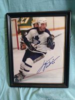 Full view of framed signed portrait photo of Tiger Williams on ice in Toronto Maple Leafs jersey with hockey stick.