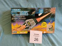 Photo of the original Star Trek The Next Generation Phaser box with detailed artwork and product labeling.