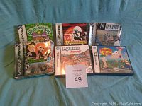 Lot of six video games laid out on a surface; three games display Gameboy Advance branding and three display Nintendo DS branding.