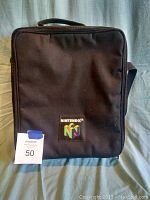 Front view of the black Nintendo 64 carrying case with logo and number tag