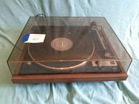 Full view of the Dual 1241 turntable with dust cover closed, showing wood base and transparent tinted plastic dust cover with markings.