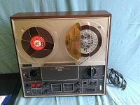 Front view of the Sony TC-366 reel to reel tape deck with tape loaded and power cord visible.