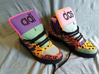 Pair of vibrant multicolor Jeremy Scott Adidas high-top running shoes showing front and side profile with chunky tongues featuring 'adi' and 'das' text.