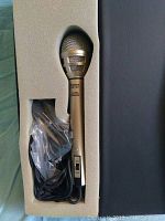 Overview of Canon CM 100 microphone in foam packaging with cable and accessory bag.