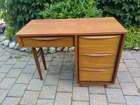Front view showing the desk's rectangular top, left drawer, and right pedestal with three drawers