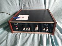 Front view of the dbx II 122 unit powered on with indicator light illuminated, showing control panel and wooden side panels.