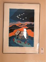 Frontal shot of framed art print showing cabin, mountains and birds with lot sticker visible