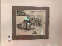 Framed pencil drawing print of Brooks Homestead hung on a wall, showing full view with matting and frame.