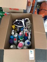 Top view of box filled with bottles of cleaning supplies and T-fal iron