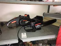 Photo of two Remington electric chain saws on a shelf, showing both saws side by side with visible branding and power cords.