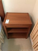 Frontal view of teak nightstand showing wood grain top and overall finish.