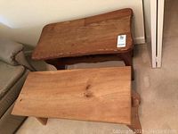 Two wooden sauna benches placed near couch, one on top of the other, showing overall size and shape.