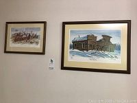 Two framed prints by Jim Robb hung side by side on a wall.