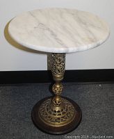 Full view of the marble top and decorative brass stem on wooden base.