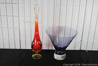 Photo of Amberina Viking glass vase and amethyst art glass bowl side by side on black fabric with white tile background