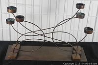 Front angle of industrial-style 6 arm magnetic candelabra, showing curved metal arms with round candle holders and magnetic bases on rectangular base.
