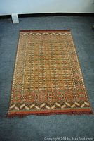 Full view of the rectangular silk oriental rug laid flat on the floor, showing overall design and colors.