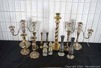 Full view of all candlesticks and vases arranged together showing different metals and styles.