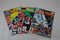 Five Star Trek comic books laid out in a fan arrangement showing full covers of issues #8, 9, 10, 18, and 50 with colorful covers featuring characters and spacecraft.