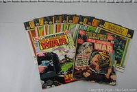 Front view displaying all 12 comic books, including Star Spangled War Stories and Golden Legacy series.