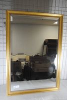 Front view of the gilt framed rectangular mirror showing beveled edges and clear reflective surface.