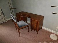 Front view of wood vanity desk and upholstered chair