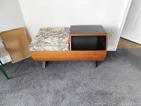 Full view of the teak telephone table showing the barrel drum base, upholstered seat, and black storage compartment.