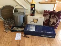 Complete overview photo showing all barware items including glasses, ice bucket, cocktail shaker, boxes of wine glasses and markers, corkscrew, and insulated wine bags.