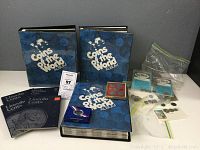 Three blue “Coins of the World” binders, two Lincoln cent folders, small red holder, mint envelopes, loose coins in bag, plastic capsules