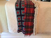 Full view of bed linens displayed on bed showing edges and textures of throws and bedspread