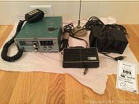 Overall view of the HeathKit ham radio with microphone, external speaker, power adapter, antenna, and cables laid out on floor.