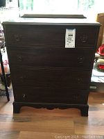 Front view showing full chest of drawers, four drawers, and original metal ring pulls, one pull appears damaged or missing.