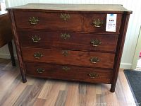 Full front view of dresser showing four drawers and brass handles.