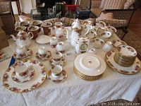 Overview of Elizabethan English Garden pattern tea service including pots, cups, saucers, plates and clock