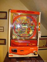 Full frontal view of the Y and O Nishijin game machine showing colorful play face with characters and red/orange casing.