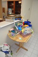 View of wooden pedestal table with cleaning supplies and tins arranged on top