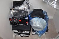 Photo of various ladies hats and purses on top of three black and white fabric storage boxes stacked against the corner of the wall.