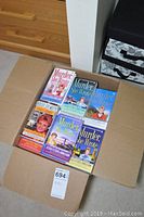 Box with six Murder She Wrote paperback books showing varied covers and titles.
