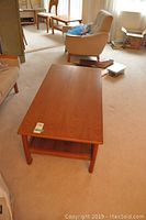Top view of wooden coffee table showing smooth surface and lower shelf