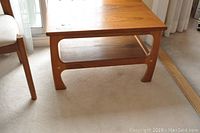 Side view of wooden side table showing the shelf and leg design