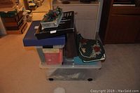 Stacked plastic storage tubs and holiday decor boxes with a green decorative mat on top