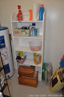 White metal shelf filled with various household products, cleaning supplies, and storage containers.